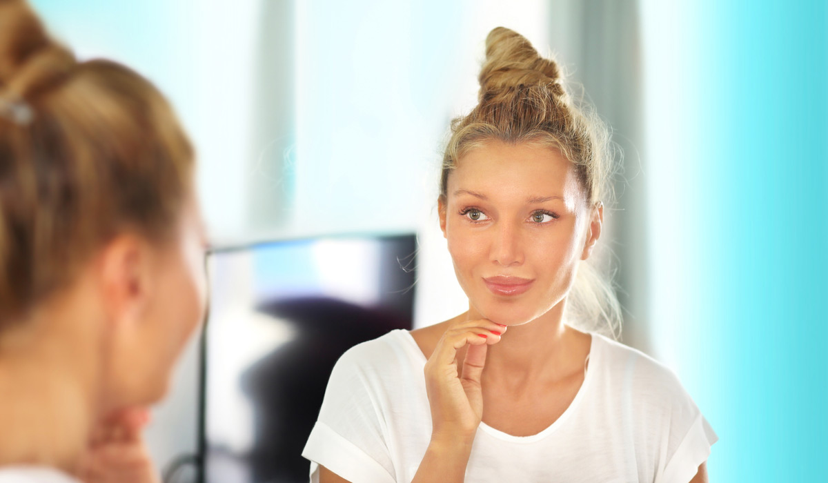 Woman-admiring-her-face-after-dermal-filler-treatment