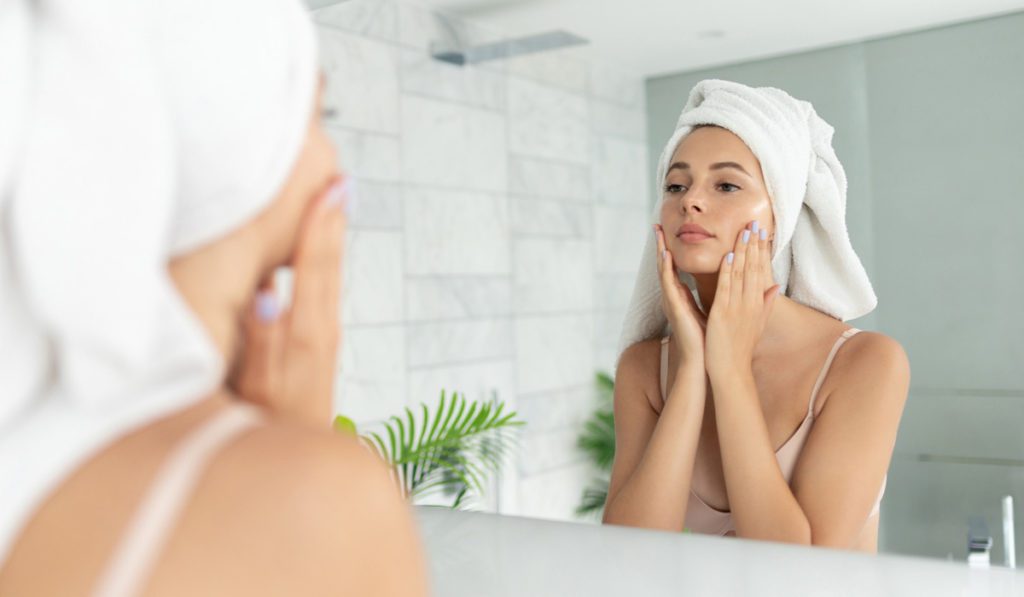 Woman-moisturizing-her-face-after-filler-treatment