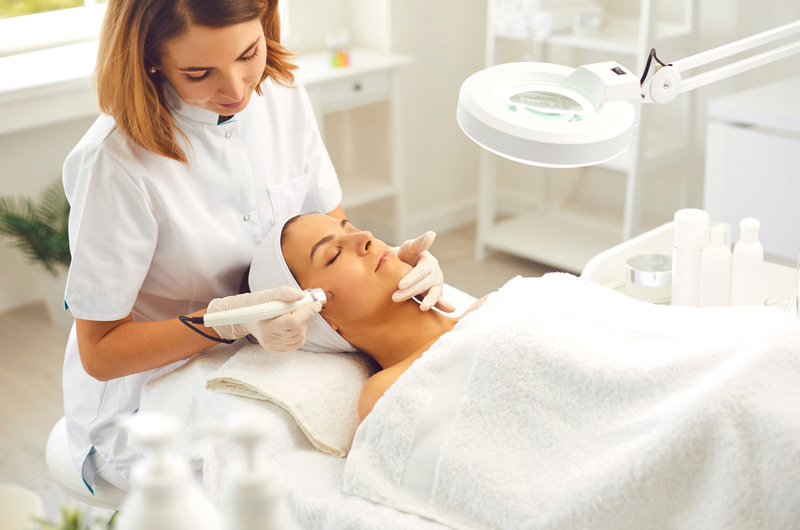 Aesthetician-treating-woman’s-face-with-dermalinfusion