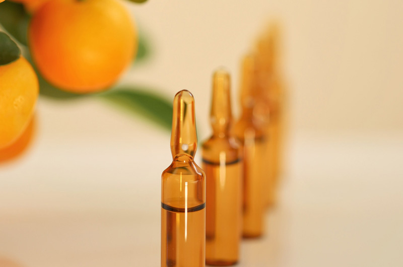 Oranges-and-vials-of-vitamin-and-mineral-injections