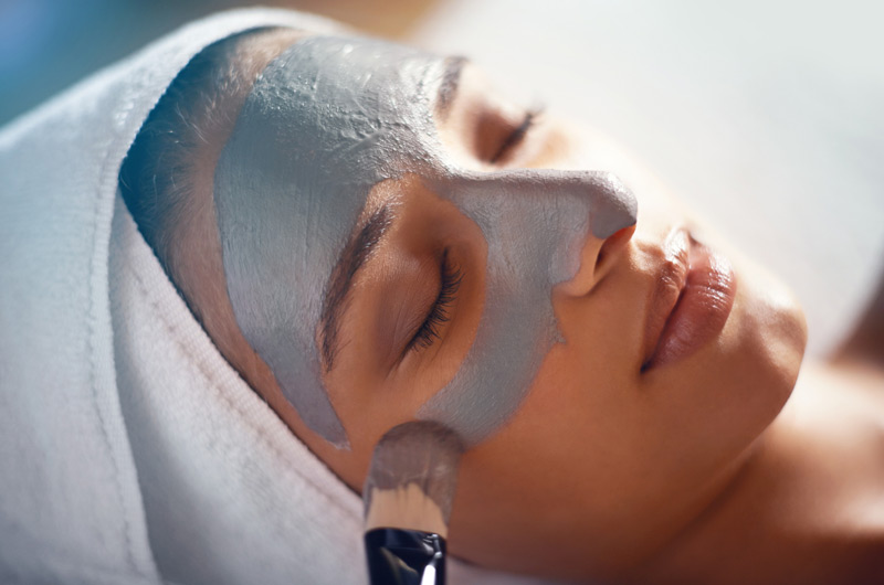 Woman-receiving-face-mask-during-facial Woman-receiving-face-mask-during-facial